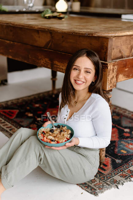 Sonriente joven sosteniendo un tazón de granola - foto de stock
