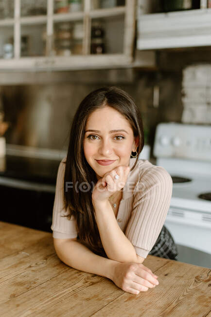 Retrato de una joven sonriente con la mano en la barbilla - foto de stock