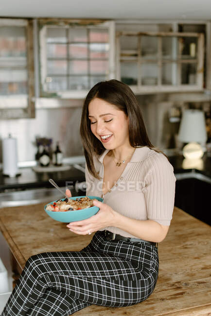 Smiling young woman holding granola bowl — Stock Photo