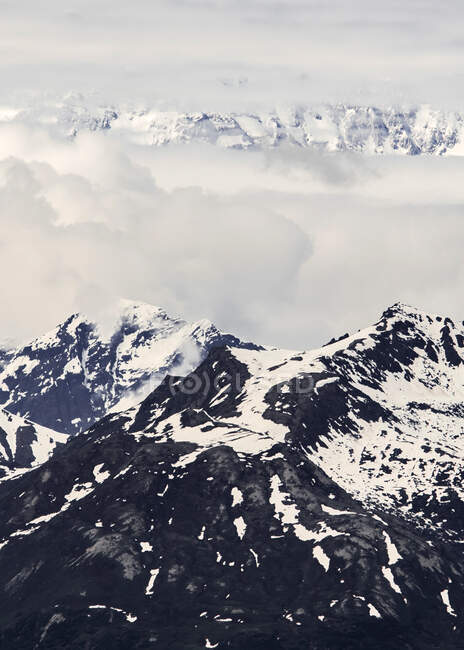 EUA, Alasca, Nuvens acima de montanhas nevadas — Fotografia de Stock