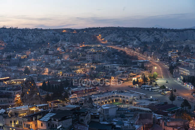 Turkey, Cappadocia, Goreme, Town illuminated at dusk and rock formations — Stock Photo