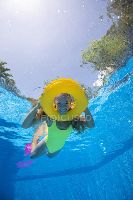 Spagna, Maiorca, Donna sorridente che nuota in piscina con anello gonfiabile — Foto stock
