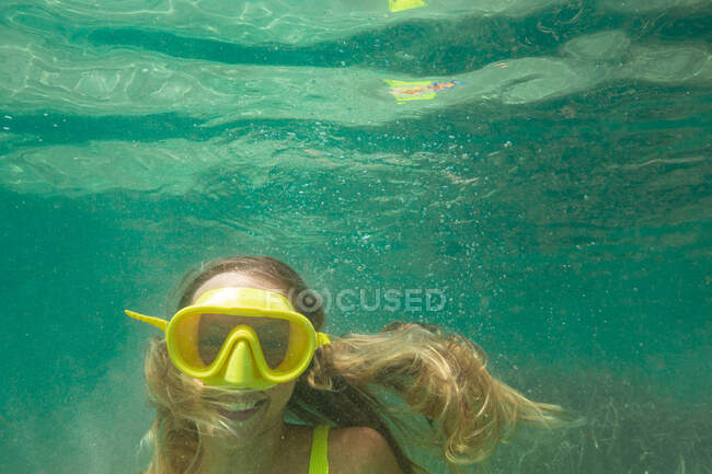 Spain, Mallorca, Smiling woman in scuba mask diving in sea — Stock Photo