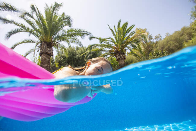 Spanien, Mallorca, Frau schwimmt im Pool auf dem Wasser — Stockfoto