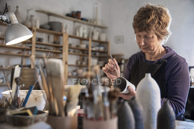 Іспанія, Балеаре, Жінка малює кераміку в майстерні. — стокове фото