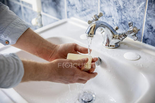 Reino Unido, Londres, Primer plano del hombre lavándose las manos en el baño - foto de stock