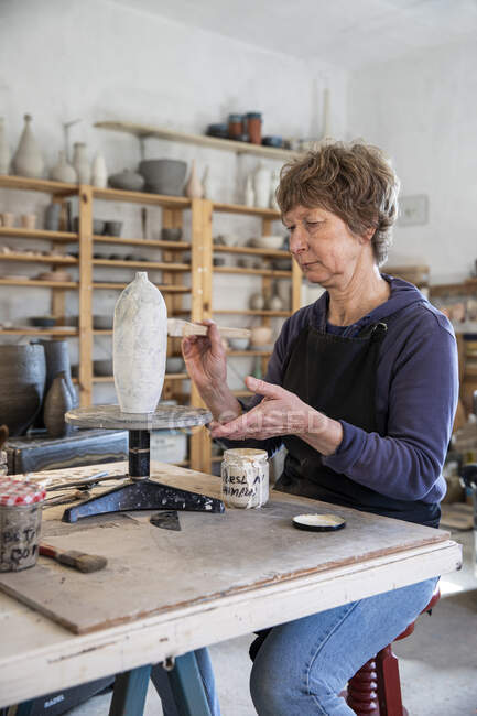 España, Baleares, Mujer pintando cerámica en taller - foto de stock