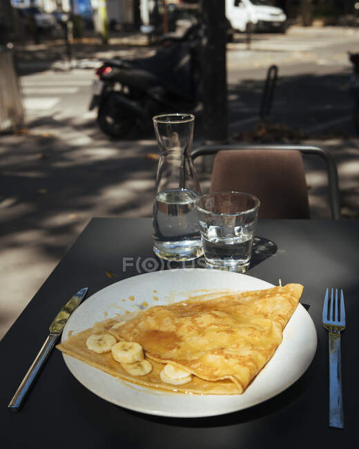 France, Paris, Crepes with banana slices on plate outdoors — Stock Photo
