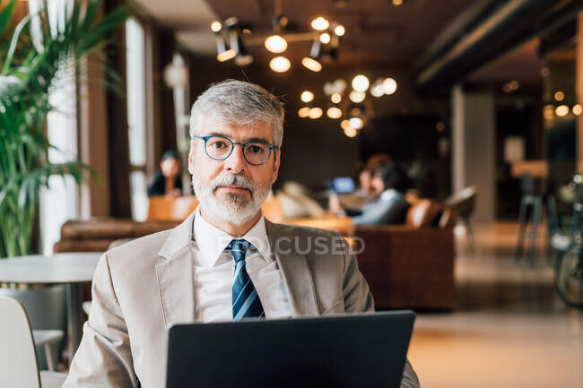Italy, Portrait of businessman with laptop in creative studio — Stock Photo