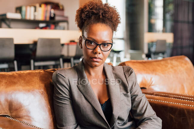 Italy, Portrait of businesswoman sitting on sofa in creative studio — Stock Photo