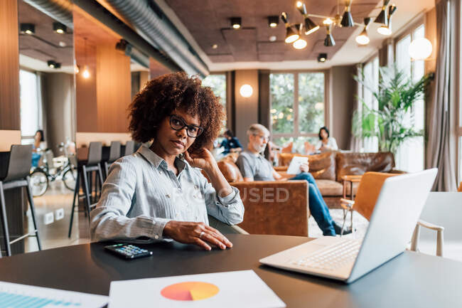 Italy, Portrait of businesswoman at table in creative studio — Stock Photo