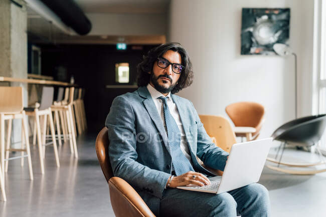 Italy, Portrait of businessman with laptop in creative studio — Stock Photo