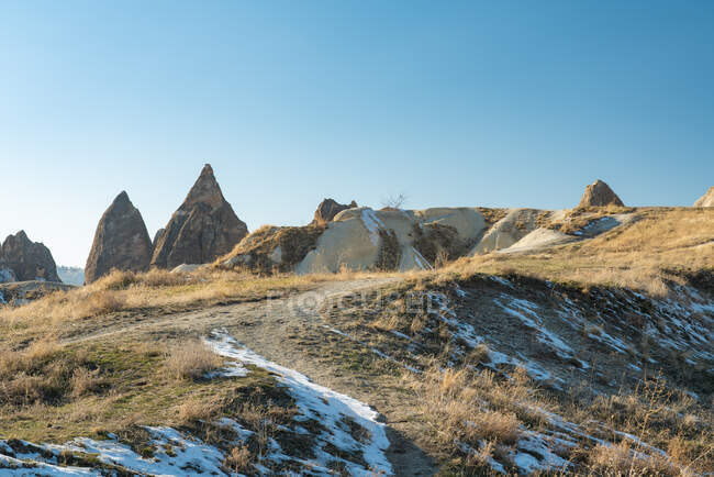 Turquía, Capadocia, Goreme, formaciones rocosas con manchas de nieve - foto de stock