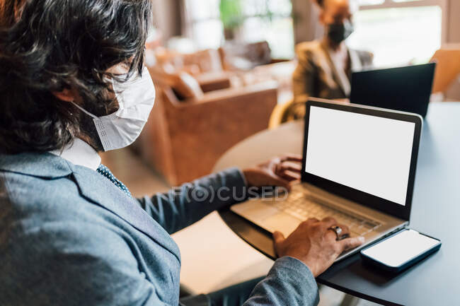 Italy, Business people in face masks working in creative studio — Stock Photo