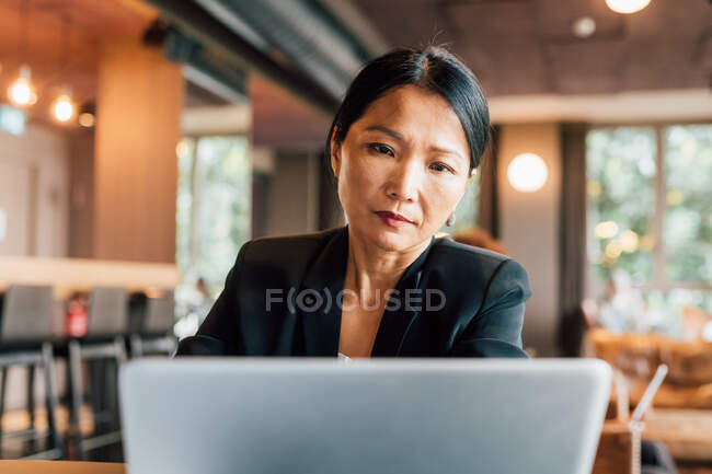 Italy, Businesswoman using laptop at table in creative studio — Stock Photo