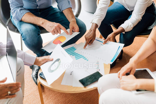 Italy, Business people pointing at graphs at meeting in creative studio — Stock Photo