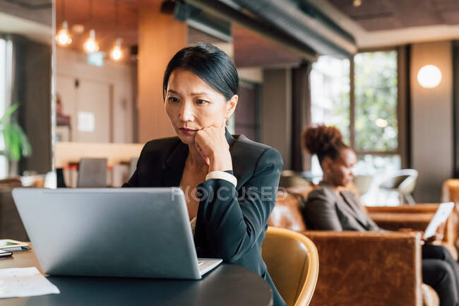 Italy, Businesswoman using laptop at table in creative studio — Stock Photo