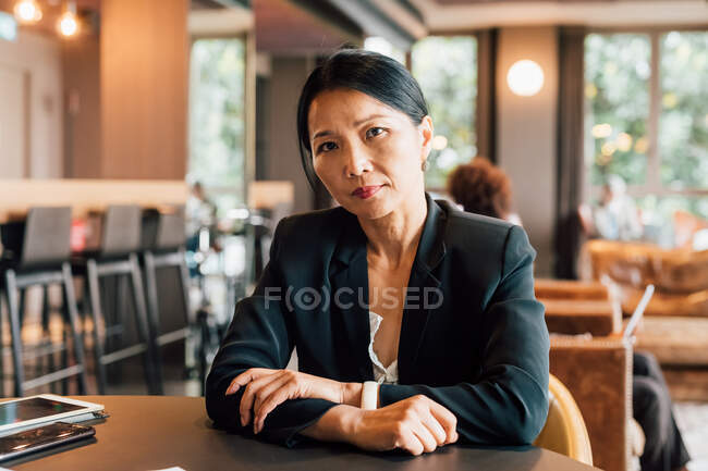 Italy, Portrait of businesswoman sitting at table in creative studio — Stock Photo