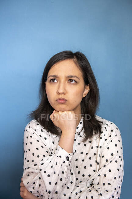 Retrato de estudio de mujer aburrida sobre fondo azul - foto de stock