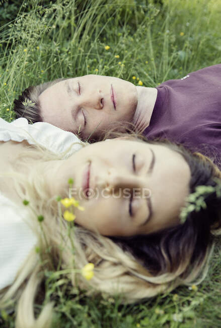 Österreich, Wien, Junges Paar mit geschlossenen Augen im Gras liegend — Stockfoto