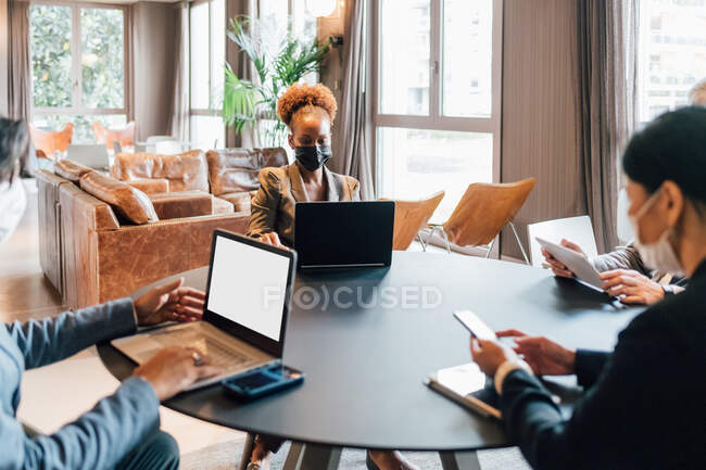 Italy, Business people in face masks having meeting in creative studio — Stock Photo