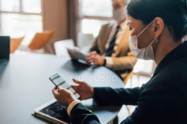 Italy, Business people in face masks working at table in office — Stock Photo