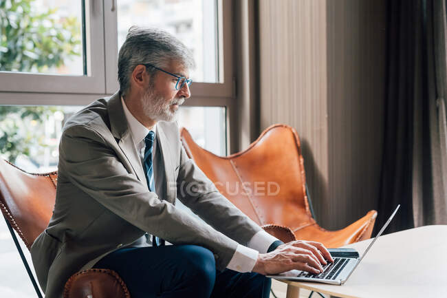 Italy, Businessman using laptop in creative studio — Stock Photo