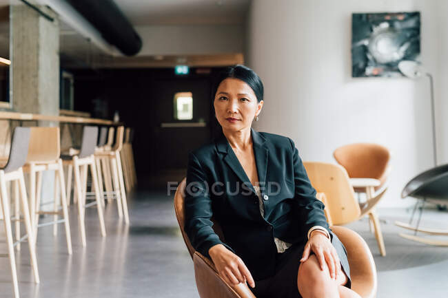 Italy, Portrait of businesswoman sitting in creative studio — Stock Photo