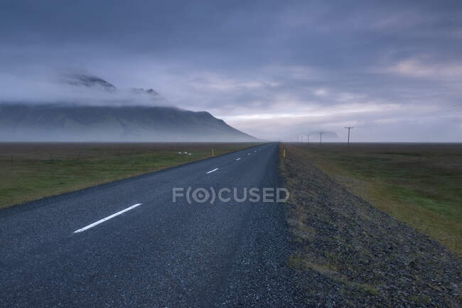 Islanda, autostrada vuota 1 che attraversa il paesaggio al crepuscolo nebbioso — Foto stock