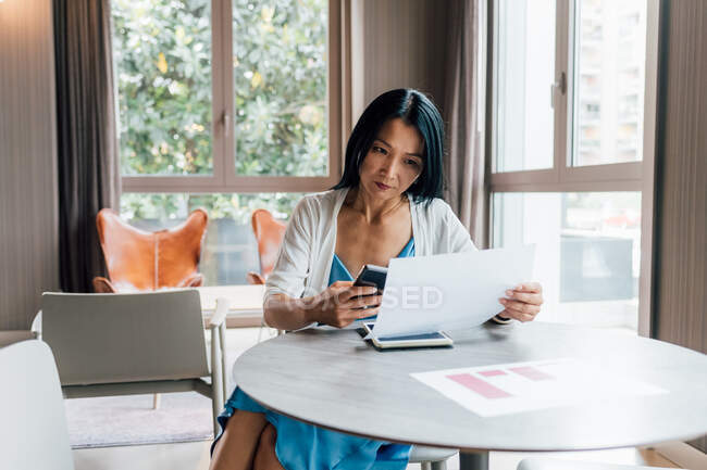 Italy, Businesswoman working at table in creative studio — Stock Photo