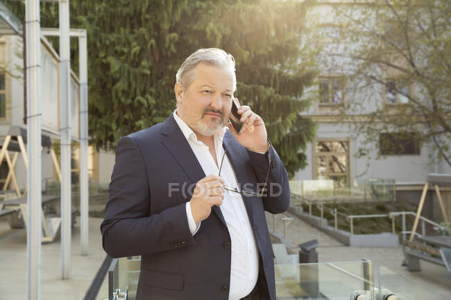 Австрія, Відень, Бізнесмен говорить по смартфону в місті — стокове фото