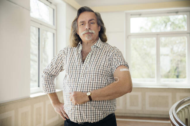 Retrato de hombre con vendaje adhesivo en el brazo - foto de stock