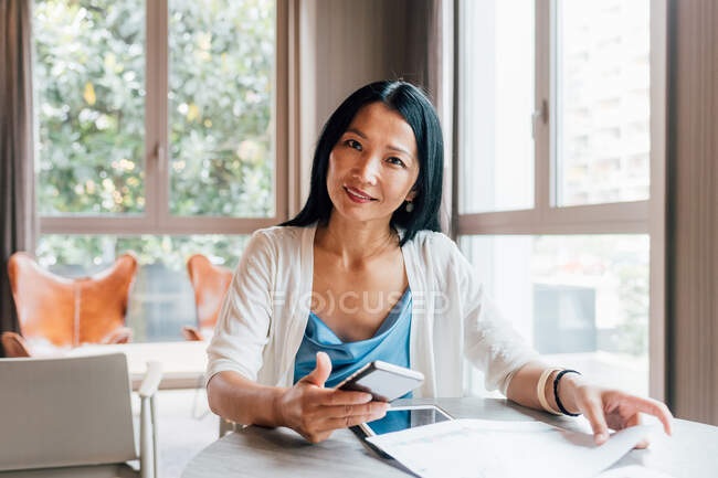 Italy, Portrait of smiling businesswoman at table in creative studio — Stock Photo