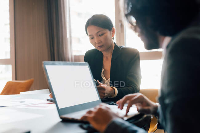 Italy, Business people at table with laptop in creative studio — Stock Photo