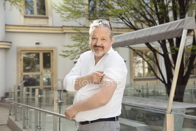 Austria, Vienna, Portrait of smiling man with adhesive bandage on arm in city — Stock Photo
