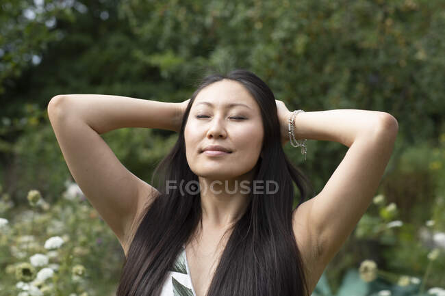 Alemania, Friburgo, Mujer joven con la cabeza en las manos al aire libre - foto de stock
