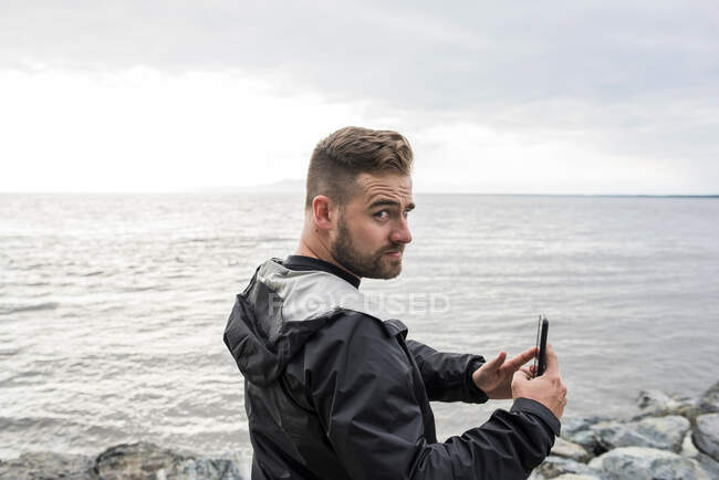 USA, Alaska, Mann mit Smartphone im Kenai Fjord Nationalpark — Stockfoto