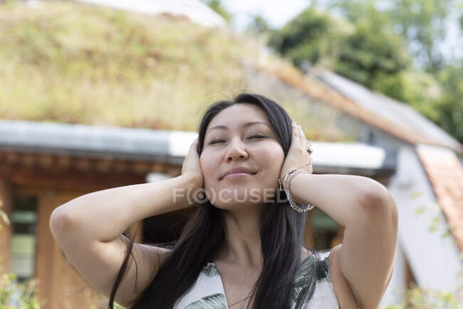 Німеччина, Фрайбург, усміхнена молода жінка з головою в руках. — стокове фото