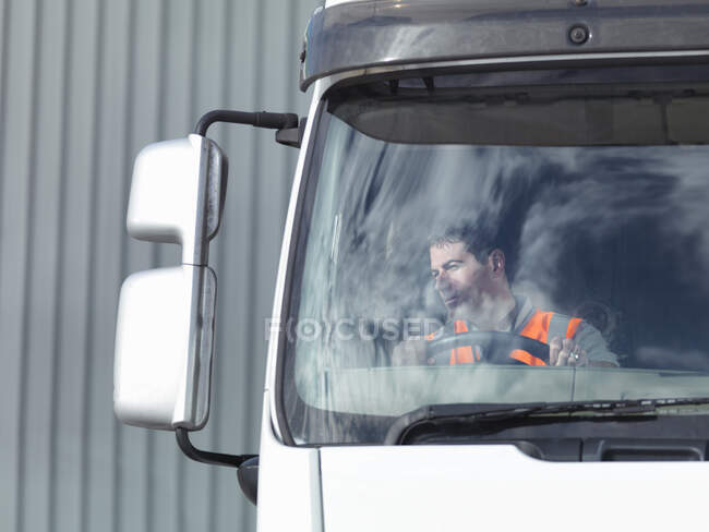 Reino Unido, conductor de camión mirando el espejo de visión lateral - foto de stock