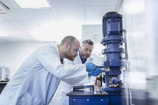 UK, Manchester, Laboratory workers using testing equipment in oil blending plant — Stock Photo