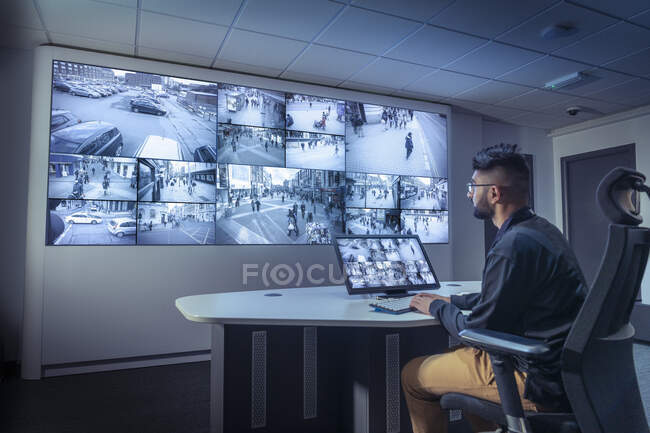 Велика Британія, Йорк, оператор дивиться на екрани в кімнаті управління CCTV — стокове фото