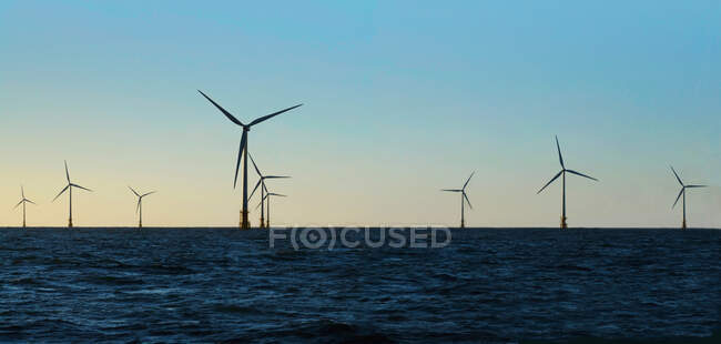Turbinas eólicas na água contra o céu azul — Fotografia de Stock
