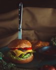 Messer in Burger mit Brot und Gemüse — Stockfoto