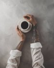 Female hands touching cup of coffee — Stock Photo