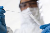 Forensic scientist putting swab into sample tube. — Stock Photo