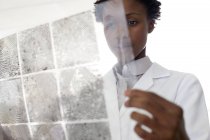 Scienziata forense donna che esamina le impronte digitali . — Foto stock