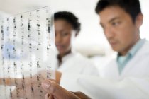 Nahaufnahme genetischer Forschungsergebnisse in den Händen von Wissenschaftlern. — Stockfoto