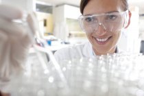 Female scientist taking testing tube from tray for scientific research. — Stock Photo