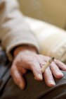 Close-up of senior man hand holding cigarette. — Stock Photo