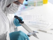 Cientista forense medindo lâmina de faca como evidência forense . — Fotografia de Stock